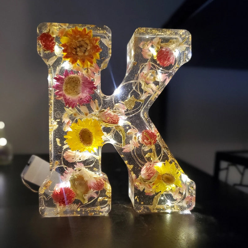 Lampada da notte illuminata con alfabeto di fiori secchi
